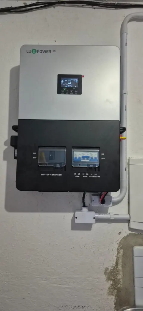 Inversor híbrido de 5 kW instalado na parede de uma pousada em Trindade, Paraty/RJ